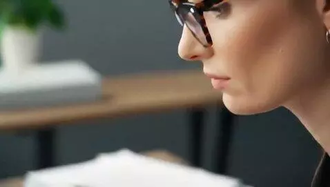 AI Video from prompt: A female office worker wearing glasses is sittin