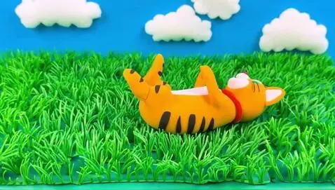 AI Video from prompt: A playful claymation cat joyfully rolling in a v