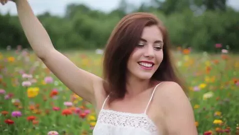 AI Video from prompt: Woman with brown hair dancing in a meadow with c