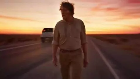 AI Video from prompt: long shot of a hitchhiker walking backwards down