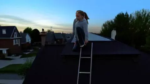 AI Video from prompt: Make a video of a girl climbing on a roof top an