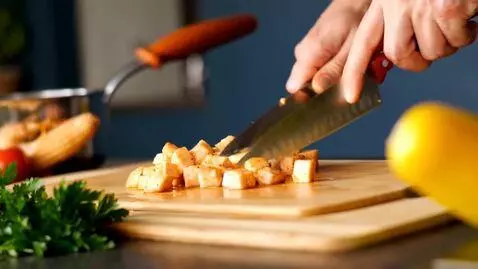 AI Video from prompt: “hands cutting chicken cubes in modern kitchen, 