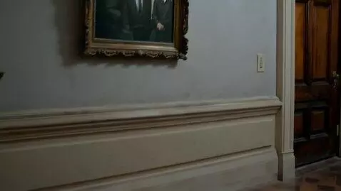AI Video from prompt: The camera glides down a dim corridor of an old 