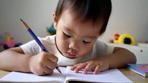 AI Video from prompt: Child writing in a book for the first time and s