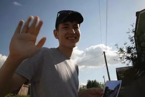 AI Video from prompt: A man with a photo smiles and waves his hand in 