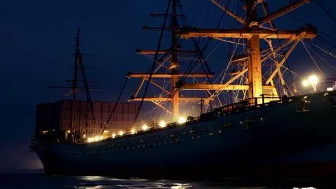 AI Video from prompt: A large ship is docked at night, lights glowing 