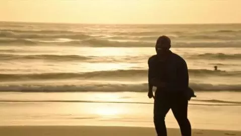 AI Video from prompt: African man runs on the beach at sunrise and hug