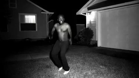 AI Video from prompt: Nighttime CCTV footage captures a black man stuc