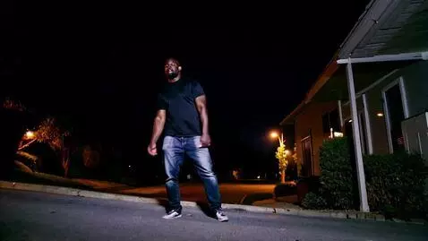 AI Video from prompt: Nighttime CCTV footage captures a black man stuc