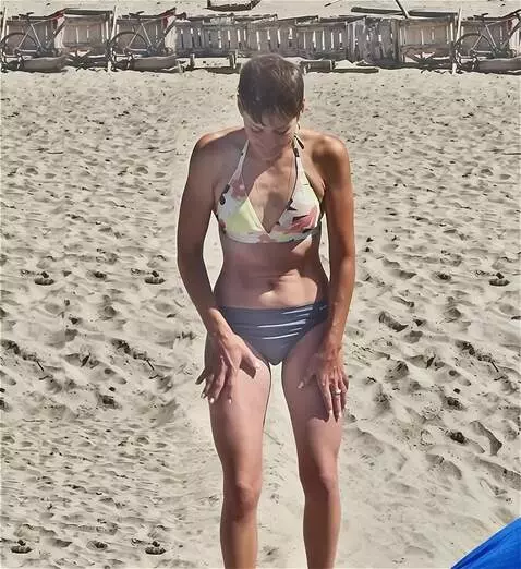 AI Video from prompt: woman sits on the sand and places her hands on h