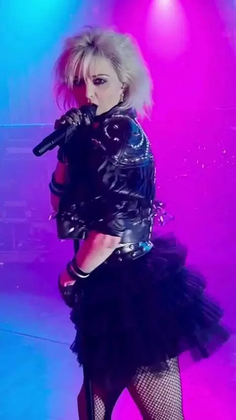 AI Video from prompt: A singer in a short tutu skirt is singing, turni