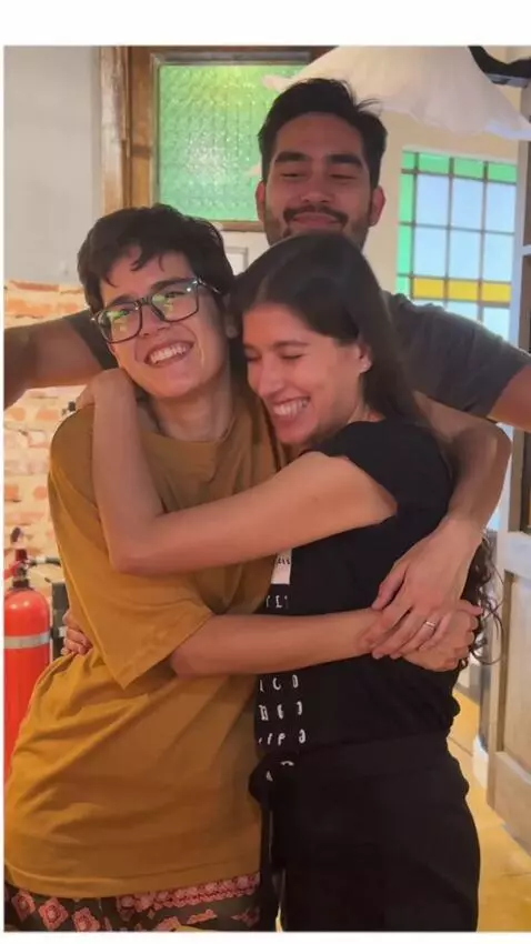 AI Video from prompt: A man hugs from behind the two women women