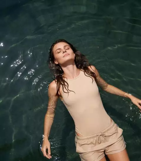 AI Video from prompt: the girl is lying relaxed on the water. she dlow