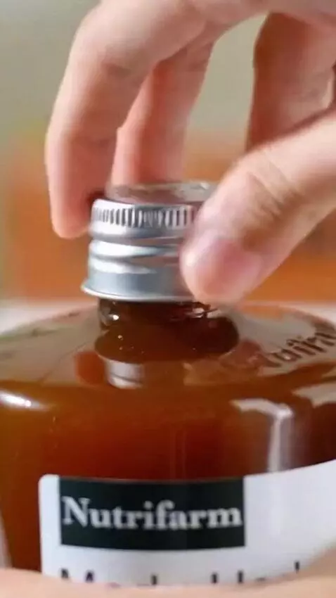 AI Video from prompt: Sebuah tangan dengan lembut mengambil sebotol ma