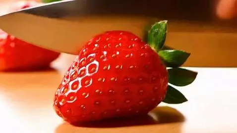 AI Video from prompt: I slowly slice the strawberries with a knife. A 