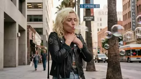 AI Video from prompt: A blonde woman is standing in the street hiccupi