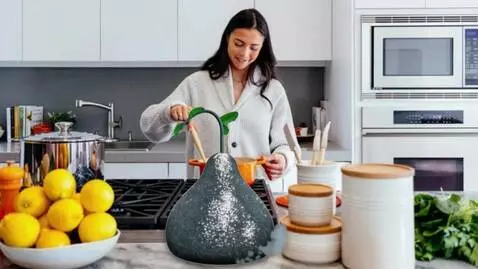 AI Video from prompt: The shot shows a kitchen with a woman stirring s