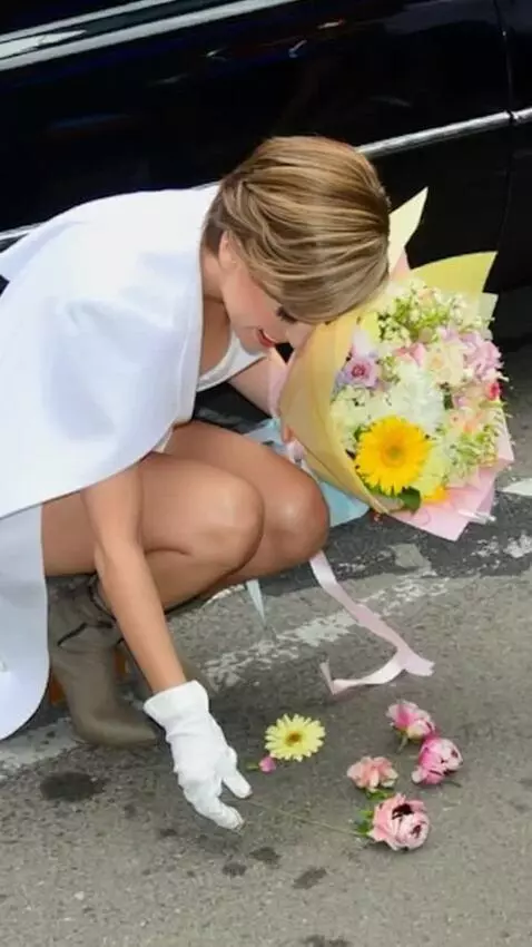 AI Video from prompt: The singer bends down to pick up the flowers.