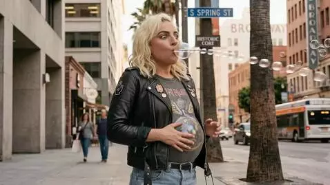 AI Video from prompt: A blonde woman is standing in the street hiccupi