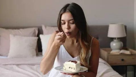 AI Video from prompt: a beatiful girl eating a piece of cake on her be