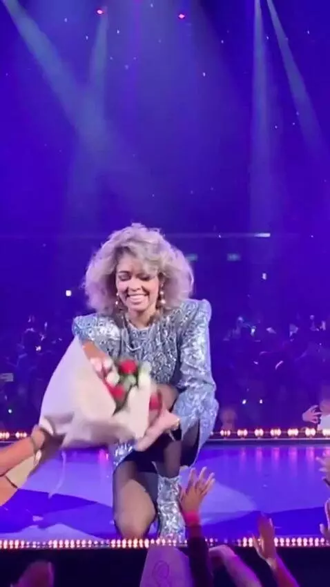 AI Video from prompt: Sandra, at the concert, in a short dress, gets d