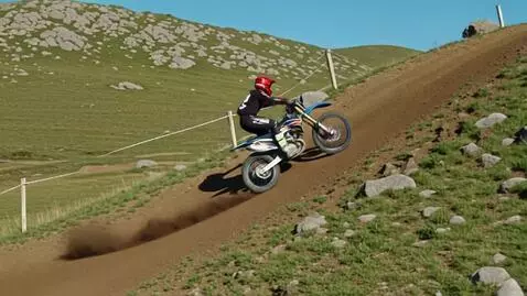 AI Video from prompt: A racing biker jumping a hilly terrain