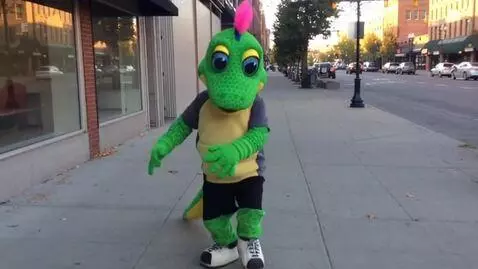 AI Video from prompt: A person inside the lizard mascot costume perfor