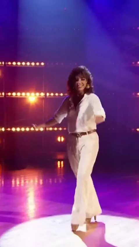 AI Video from prompt: Sandra is on stage in a short, sheer dress, danc