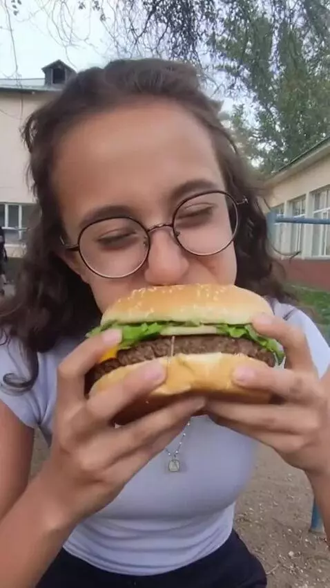 AI Video from prompt: A girl sits. A white chicken walks up to her and