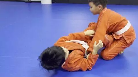 AI Video from prompt: two boys at six years,wearing orange bjj jackets