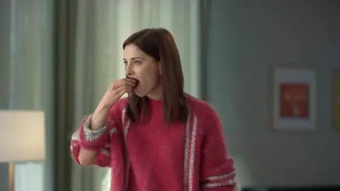 AI Video from prompt: she tilts her head towards the object, puts in i
