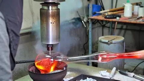 AI Video from prompt: A craftsman blows a vase out of molten glass. Th