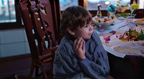 AI Video from prompt: Show a child looking out a window, waiting, perh