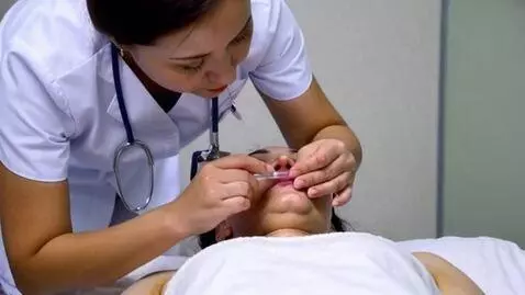 AI Video from prompt: nurse bends over to take the patient's temperatu