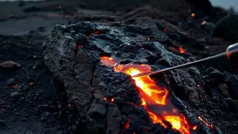AI Video from prompt: A sharp blade presses against a rough, black lav
