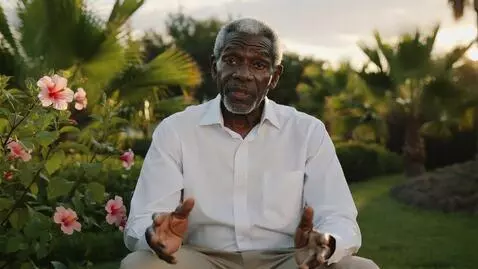 AI Video from prompt: A charismatic 70-year-old Black man sitting in a