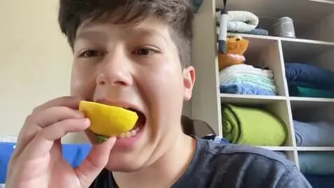 AI Video from prompt: This person is eating a lemon and then his face 