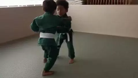AI Video from prompt: two boys at six years,wearing green bjj jackets,
