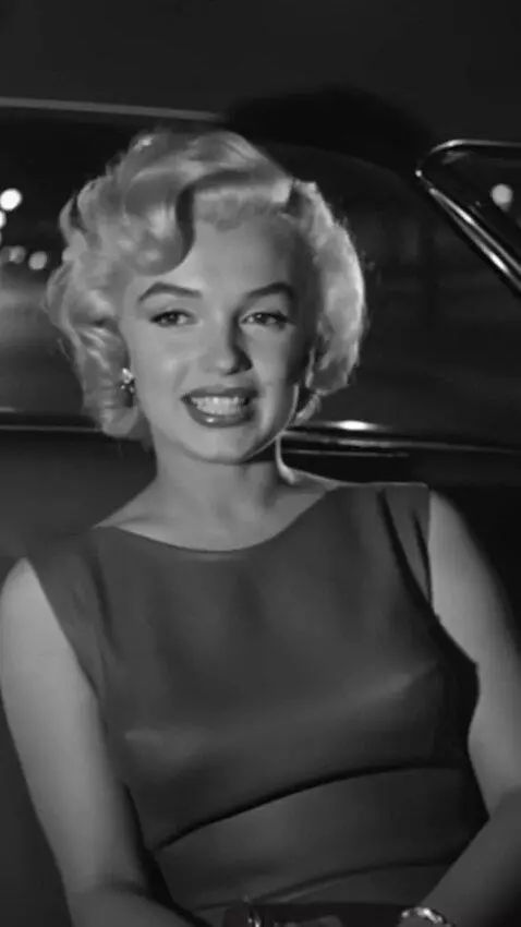 AI Video from prompt: Marilyn Monroe is riding in the back seat in a s