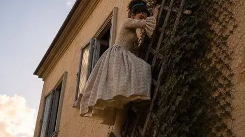 AI Video from prompt: The girl climbs down the trellis, wind fuffling 