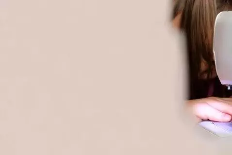 AI Video from prompt: a young girl sewing on a sewing machine