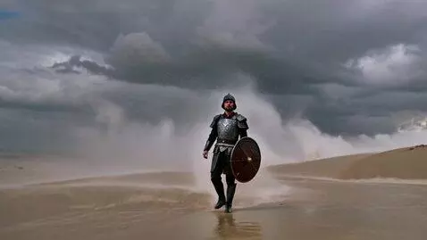 AI Video from prompt: Brave Knight walking in a rainstorm on desert du