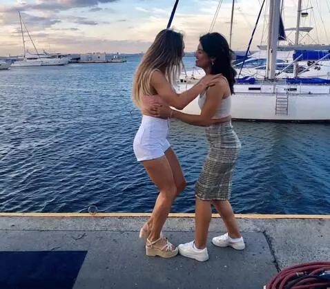 AI Video from prompt: girls look at sea, and dancing slow moves ass, s