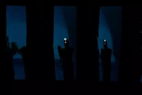AI Video from prompt: A dark room lined with tall, cracked mirrors. In