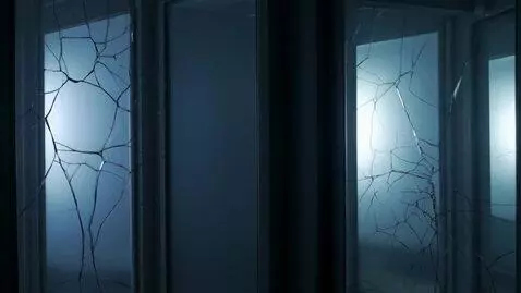 AI Video from prompt: A dark room lined with tall, cracked mirrors. In