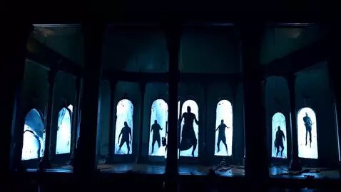AI Video from prompt: A dark room lined with tall, cracked mirrors. In