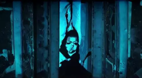 AI Video from prompt: A dark room lined with tall, cracked mirrors. In