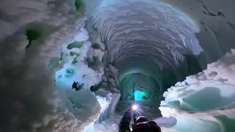 AI Video from prompt: An expedition to an ice cave. The explorer shine