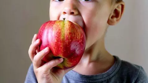 AI Video from prompt: Child eating beautiful apple fruit