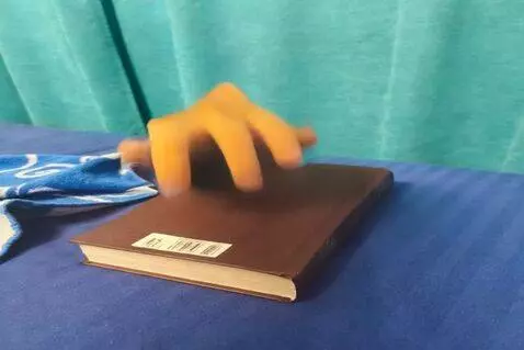 AI Video from prompt: The hand crawls over the book. Then the hand jum